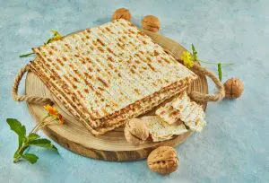 pesach-celebration-concept-jewish-passover-holiday-matzah-on-wooden-stand-with-nuts-1024x698