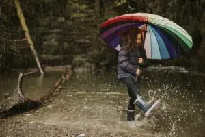 Little girl using an umbrella in stream on a rainy day