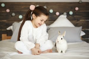 girl-and-rabbit-sitting-on-bed