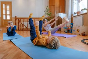 active-grandmother-doing-yoga-with-her-grandchildren-in-the-kids-room-indoor-1536x1024